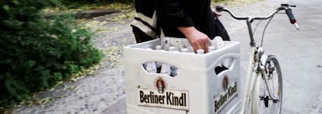 Alberto con su bicicleta y una caja de cerveza berlinesa