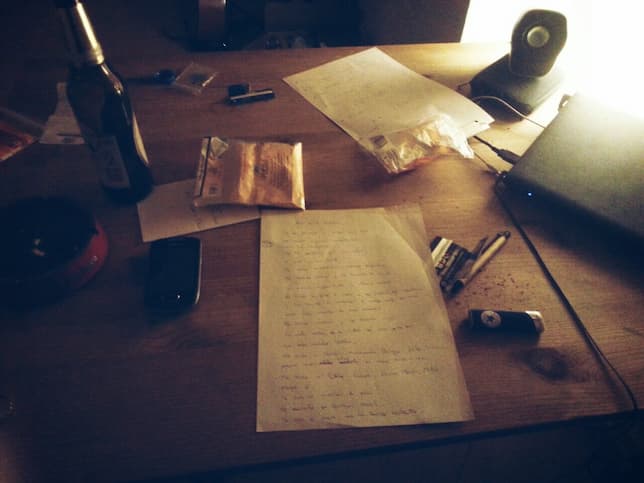 Una mesa llena de notas para canciones, cerveza y tabaco
