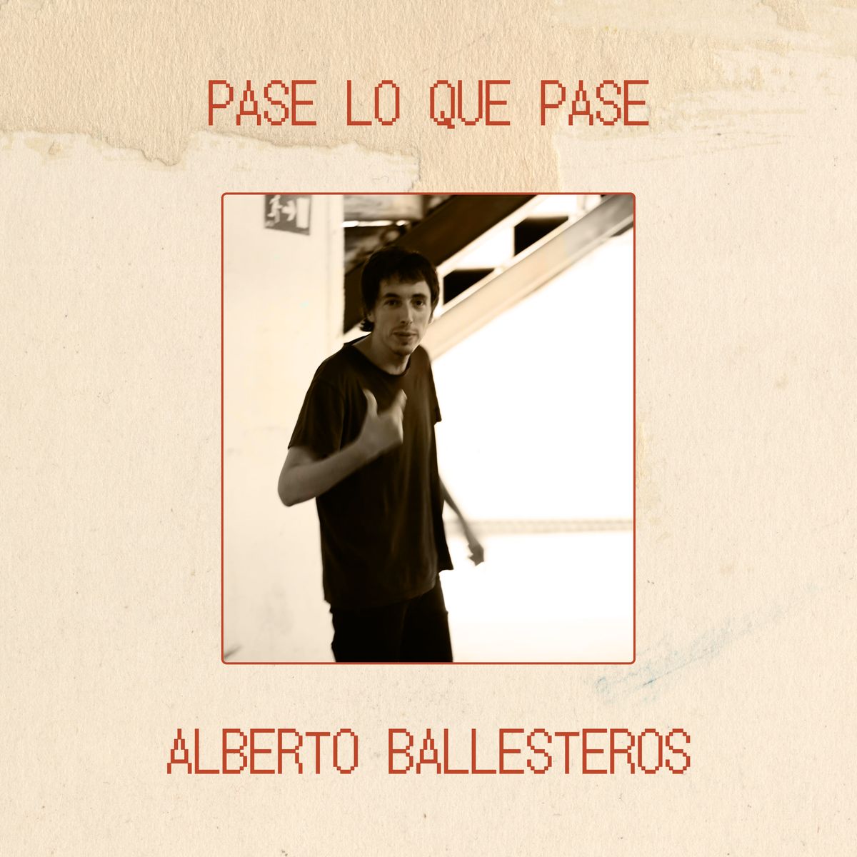 Portada del sencillo \"Pase lo que pase\" de Alberto Ballesteros. Fondo de papel texturizado beige con una foto central con Alberto mirando a la cámara en un espacio urbano.